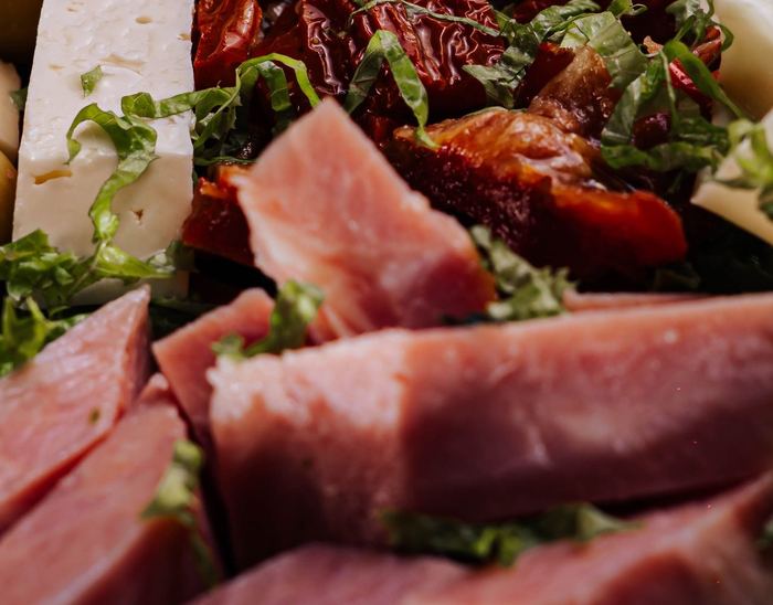 Jamón cocido en trozos sobre hojas verdes
